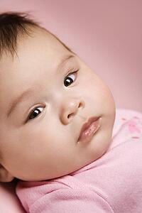 Close up of Asian babys face looking at viewer.