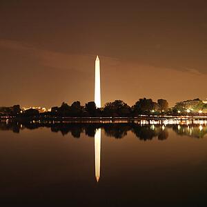 Washington Monument reflected in water at night in Washington, D. C., USA.
