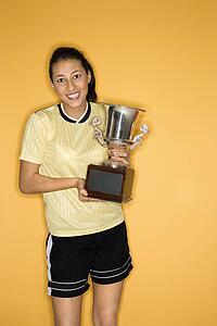 Portrait of Multi-racial teen girl holding trophy.