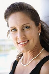Portrait of mid-adult Caucasian female smiling and making eye contact.