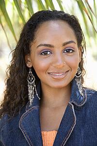 Young-adult Black female smiling and making eye contact.