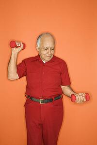 Mature adult Caucasian male lifting hand weights.