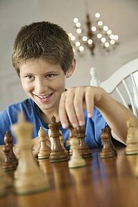 Caucasian pre-teen boy playing chess.