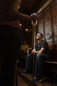 Young man holding billiards cue while hanging out at pub.