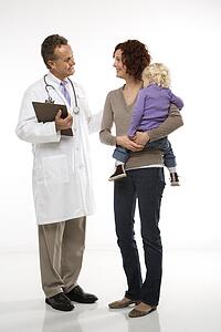 Middle-aged adult Caucasian male doctor introducing himself to mid-adult mother and her daughter.
