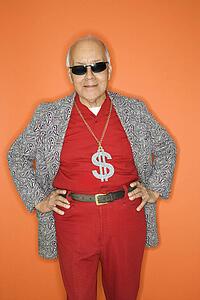 Mature adult Caucasian male wearing money sign necklace.