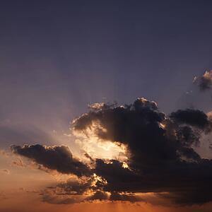 Sun shining through dark cloud.