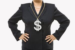 Close-up of Filipino middle-aged businesswoman wearing chain necklace with oversized dollar sign.