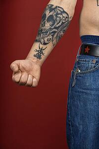 Caucasian mid-adult man's arm with tattoo.