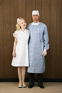 Mid-adult Caucasian female nurse and male doctor standing together and smiling.