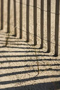 Close-up of fence and shadows on beach on Bald Head Island, North Carolina.