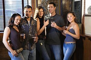 Group of young friends hanging out in pub and drinking beer.