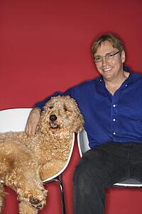 Middle-aged Caucasian man with Goldendoodle dog.