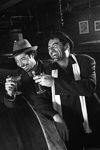 Caucasian prime adult retro males sitting at bar drinking.