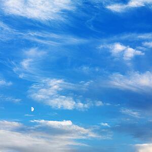 Wispy cloud formations against clear blue sky.
