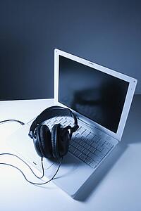 Headphones placed on laptop computer.