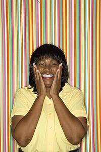African-American mid-adult woman looking surprised and happy.