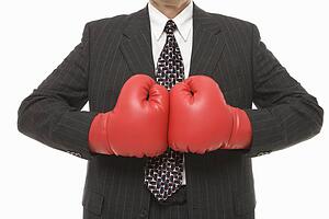 Caucasian middle-aged businessman wearing boxing gloves 