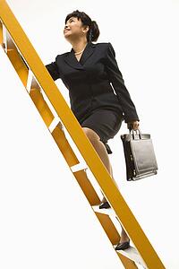 Filipino middle-aged businesswoman climbing ladder carrying briefcase.
