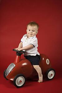 Portrait of Caucasian male child driving play car.
