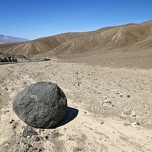 Boulder in barren landscape in Death Valley National Park.
