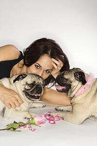Caucasian prime adult female with two Pug dogs.