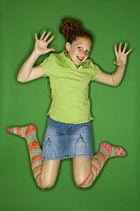 Caucasian female child jumping.