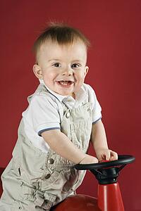 Portrait of Caucasian male child driving play car.