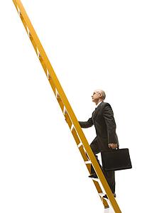 Caucasian middle-aged businessman climbing ladder carrying briefcase.