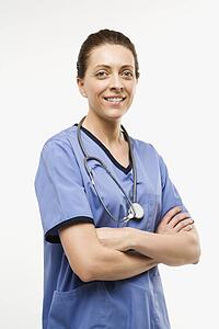 Portrait of smiling Caucasian woman doctor standing against white background.
