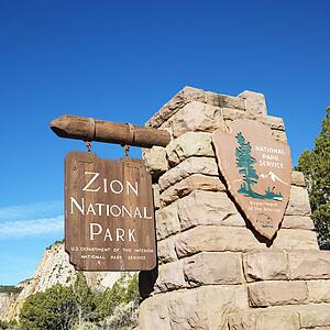 Wooden and stone sign for Zion National Park, Utah.