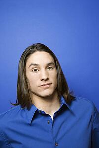 Portrait of Asian-American teen boy against blue background. 