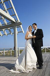 Caucasian mid-adult bride and groom wedding portrait outside at beach.