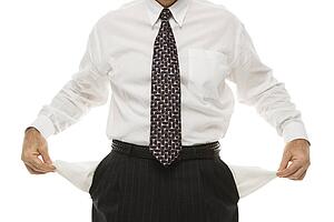 Caucasian middle-aged businessman pulling empty pockets out standing against white background.