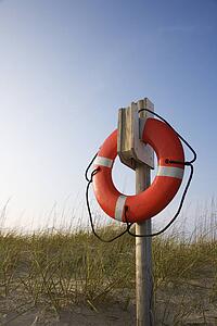 Life preserver hanging on post on beach on Bald Head Island, North Carolina.