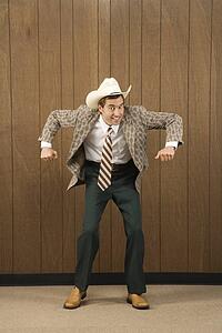 Mid-adult Caucasian male wearing cowboy hat dancing.