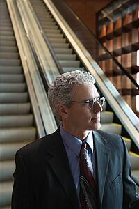 Close up of prime adult Caucasian man in suit on escalator.