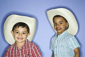 Hispanic and African American male child in cowboy hats.