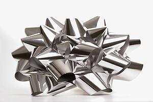 Still life of big shiny silver Christmas bow.