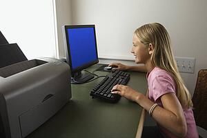 Caucasian pre-teen girl using computer.