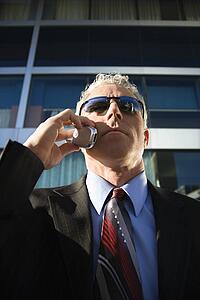 Prime adult Caucasian man in suit talking on cellphone in urban setting.