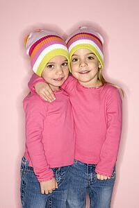 Young female twin Caucasian children standing together.