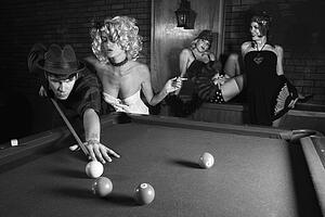 Prime adult Caucasian retro male shooting pool with three Caucasian prime adult retro females watching.