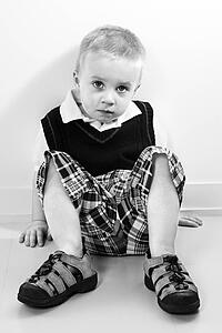 Caucasian boy sitting on floor.