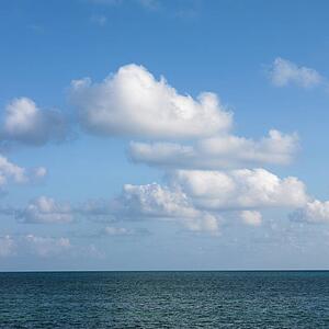 Calm water and blue sky with white puffy clouds in Florida Keys, Florida, USA.