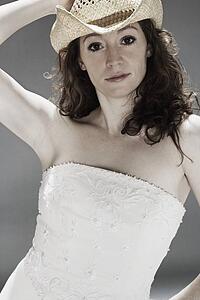 Woman wearing a wedding dress and cowboy hat