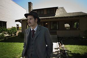 Man in vintage clothing outside of house