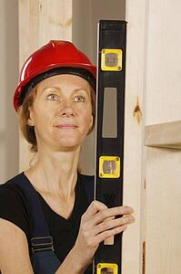 Female construction worker using a level