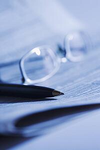 Pen and glasses on newspaper