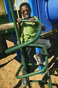 A young boy climbing on playground equipment